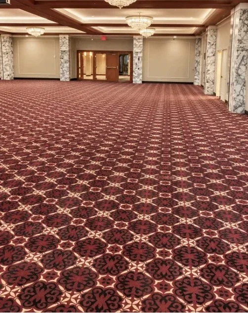 Large ballroom with chandeliers and a red and black patterned commercial carpet